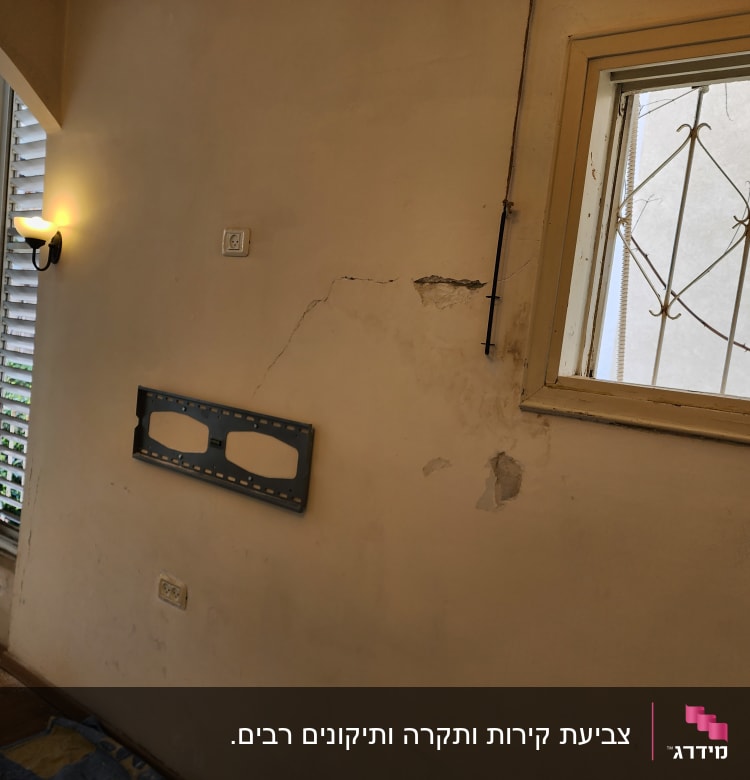 קיר עם סדקים ותושבת מתכת, מוכן לצביעה